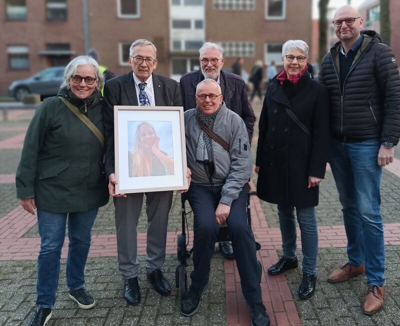 Sechs Mitglieder des Klosterpforte e.V. stehen zusammen auf einem Platz in Kleve, einer von ihnen hält ein gerahmtes Porträt.