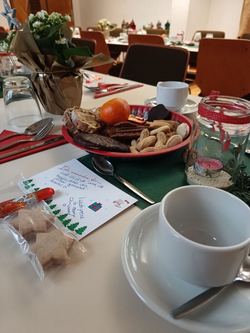 Festlich gedeckter Tisch in der Klosterpforte mit Gebäck, Obst und einer selbst gemalten Weihnachtskarte.